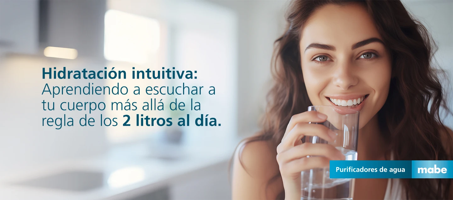 Mujer sonriendo mientras bebe agua con el texto 'Hidratación intuitiva: Aprendiendo a escuchar a tu cuerpo más allá de la regla de los 2 litros al día'. Campaña de purificadores de agua mabe
