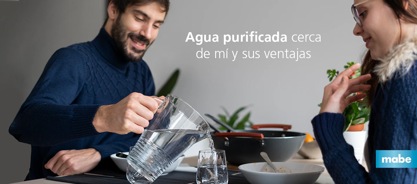 Pareja sirviendo agua purificada de una jarra durante la comida, con el texto “Agua purificada cerca de mí y sus ventajas